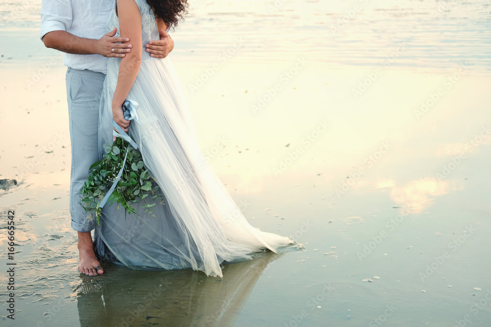 Φωτογραφία Couple of lovers embracing standing barefoot in shallow water