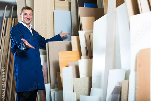 workman standing with plywood pieces photo