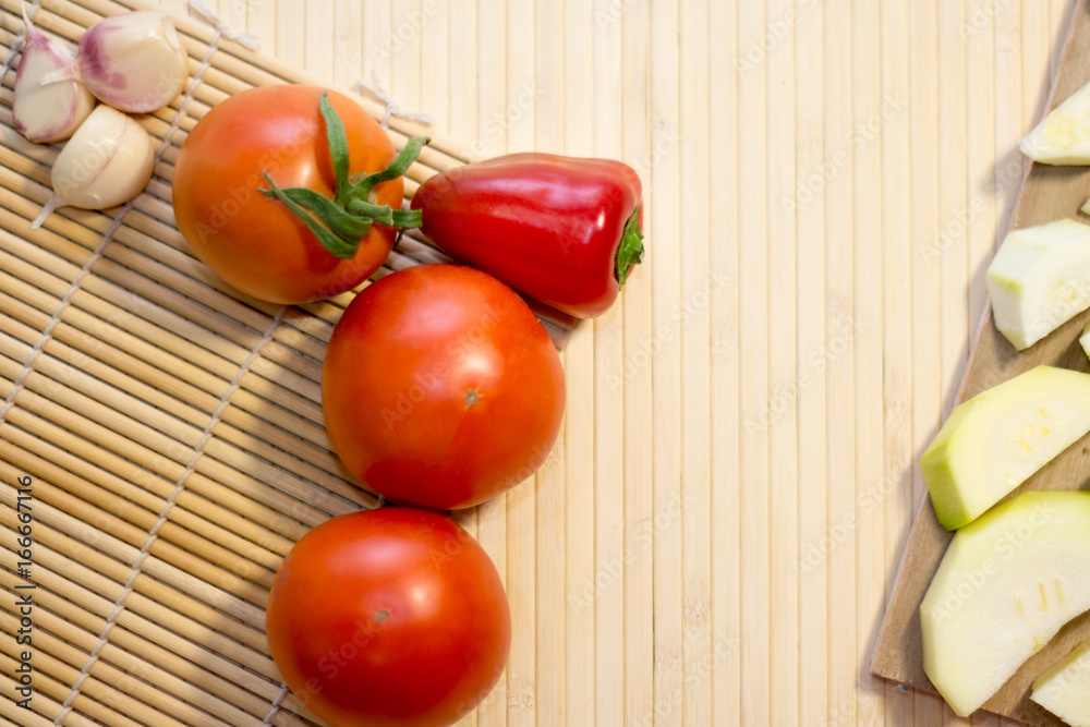 Tomatoes on vine, zucchini, squash, cucumbers and salad on white rustic wooden background Tomatoes on vine, zucchini, squash, cucumbers and salad on white rustic wooden background