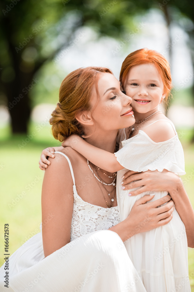 mother and daughter hugging at park
