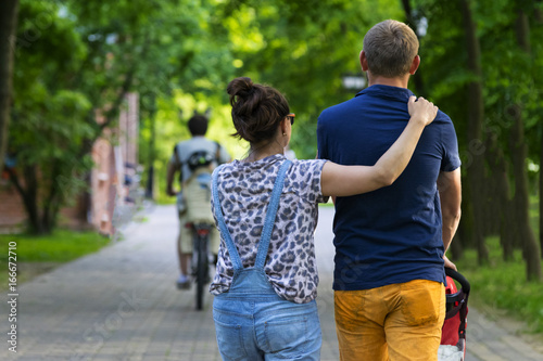 Young couple walking with child in the Park. Summer.