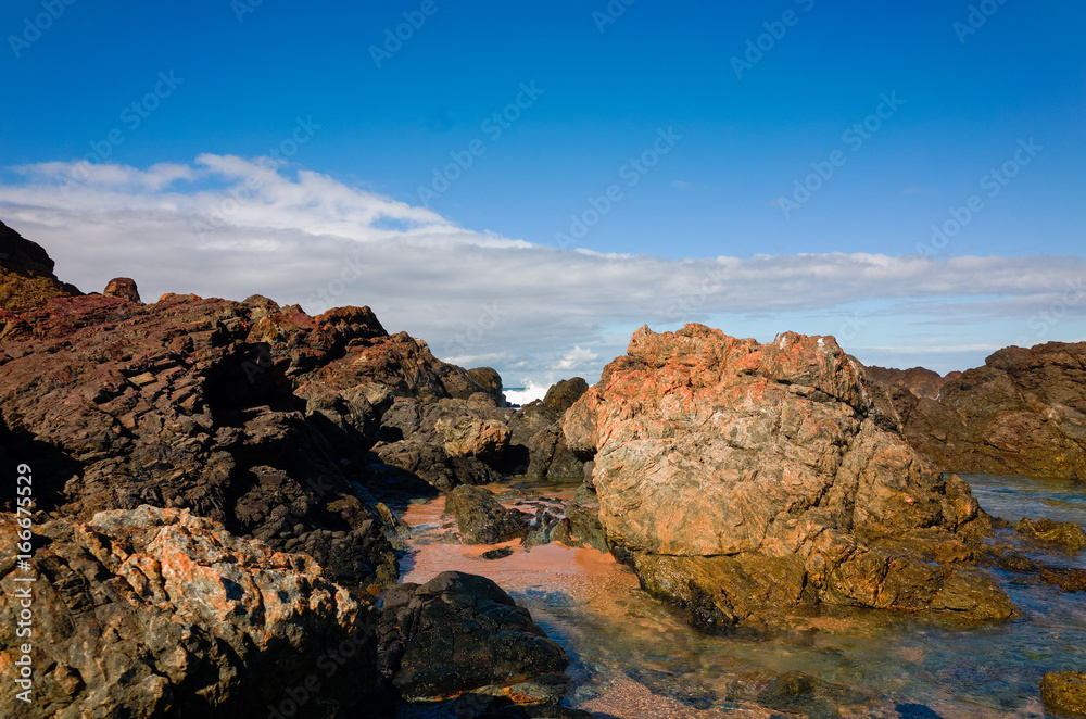 Large rock formations on sandy beach at Port Macquarie Australia