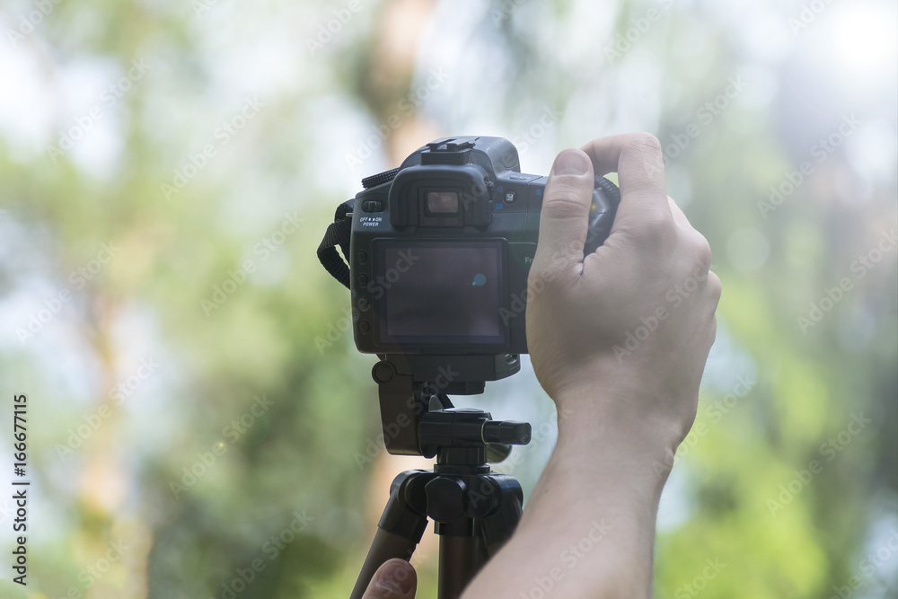 The man sets the camera on a tripod The man sets the camera on a tripod