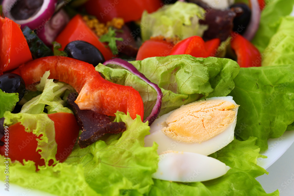 salad from fresh vegetables in a plate on a table, selective focus