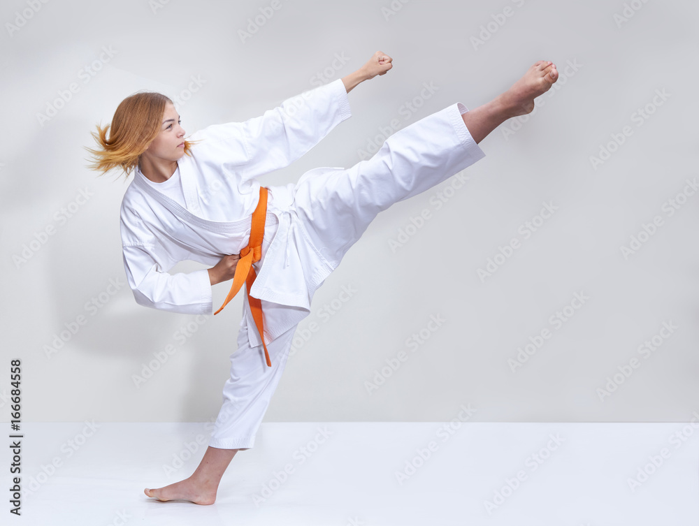 With an orange belt the girl beats a kick With an orange belt the girl beats a kick
