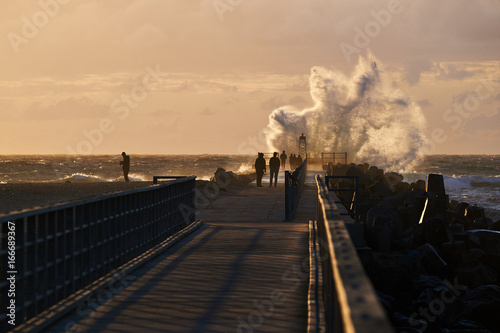 wave hits the pier at sunset in nr. Vorupoer at the North Sea Coast in Denmark © lavrsen