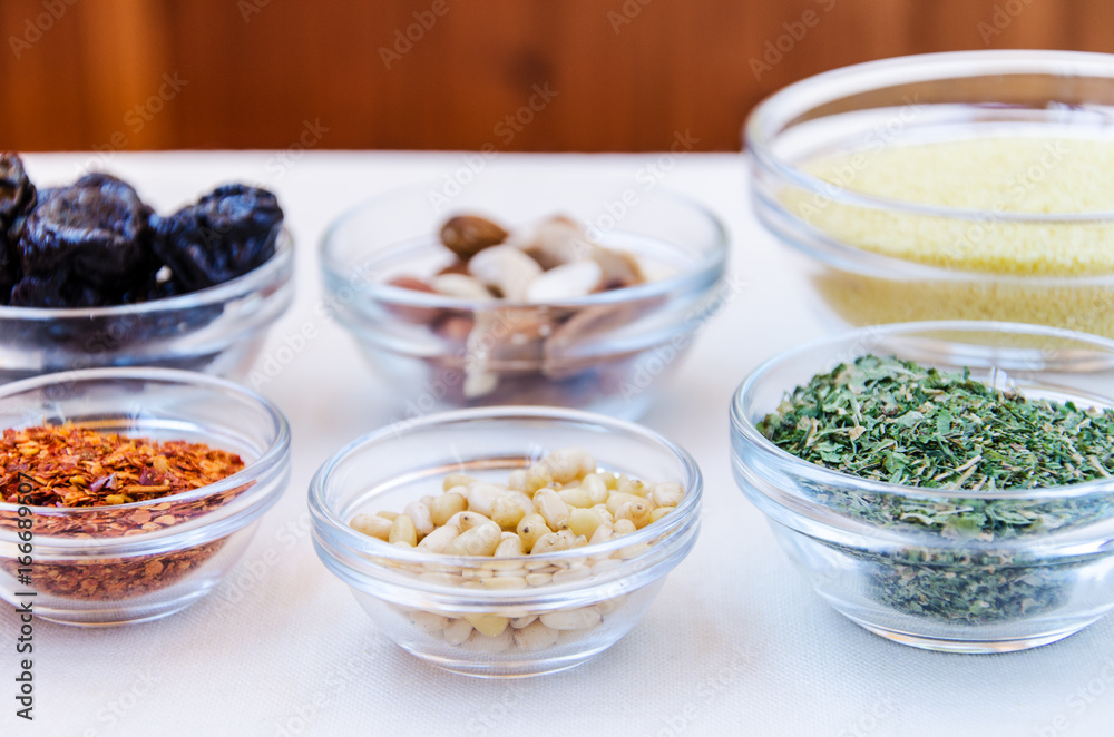 Variety of ingredients for couscous cooking in glass bowls Variety of ingredients for couscous cooking in glass bowls
