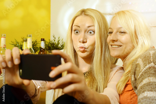 Frau mit Freundin auf Party fotografiert Selfie mit Smartphone