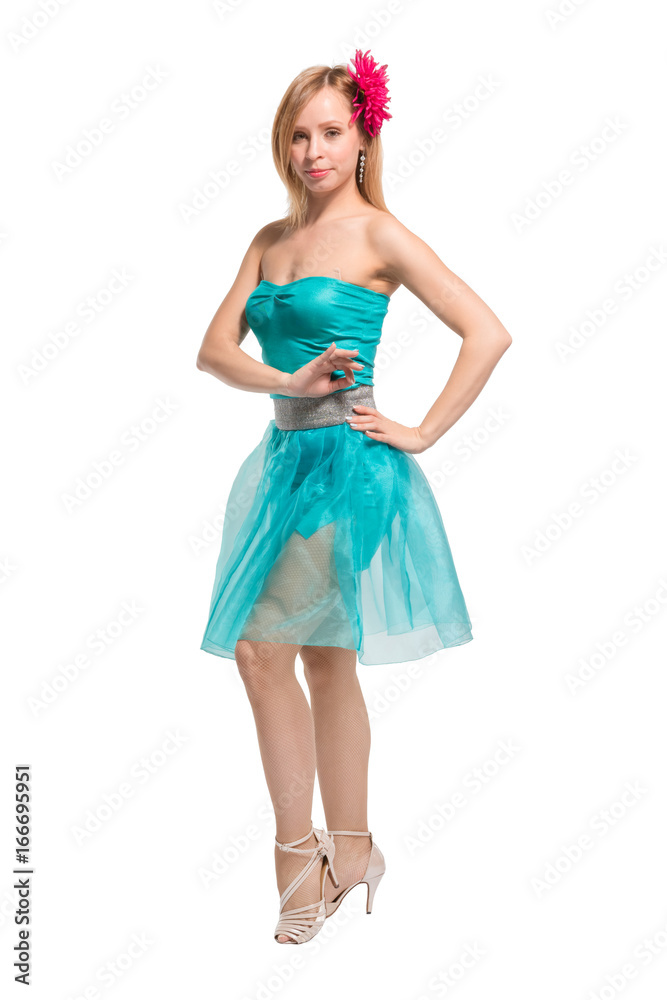 Beautiful young blonde girl in a blue top, blue skirt and a pink barrette in the shape of a flower on her head dancing
