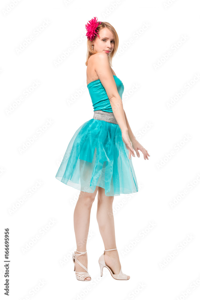 Beautiful young blonde girl in a blue top, blue skirt and a pink barrette in the shape of a flower on her head dancing
