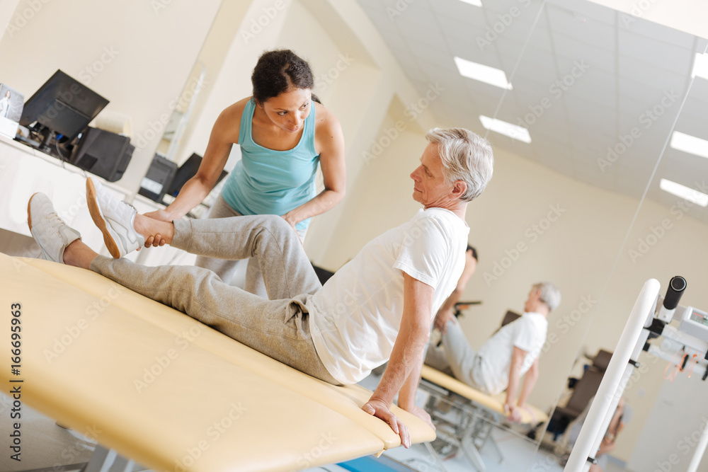 Pretty trainer explaining task for stretching leg