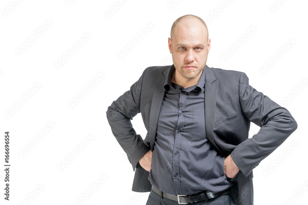 Bald man in a gray suit standing with hands on hips. Isolated Bald man in a gray suit standing with hands on hips. Isolated