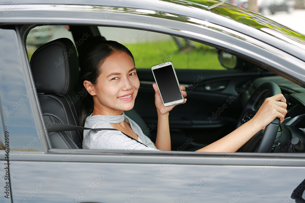 Woman driver using smart phone in car.