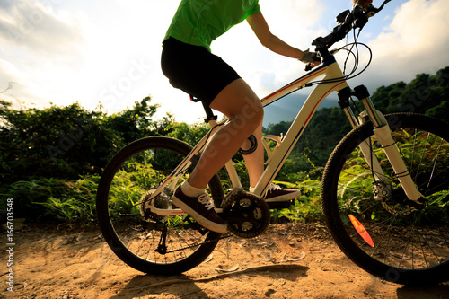 Woman cyclist cycling mountain bike on trail © lzf
