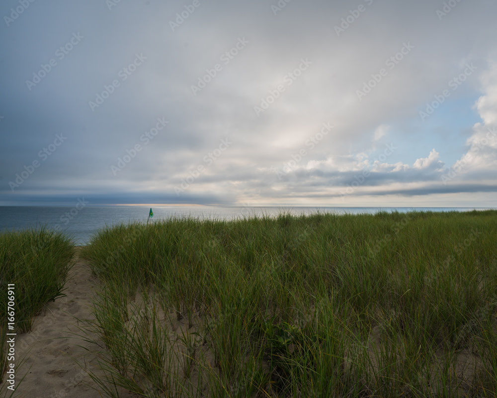 Nantucket ocean beach at sunrise with clouds and seagrass