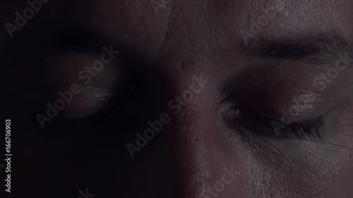Close up of male eyes opening in fear after bad dream or nightmare in bed at night