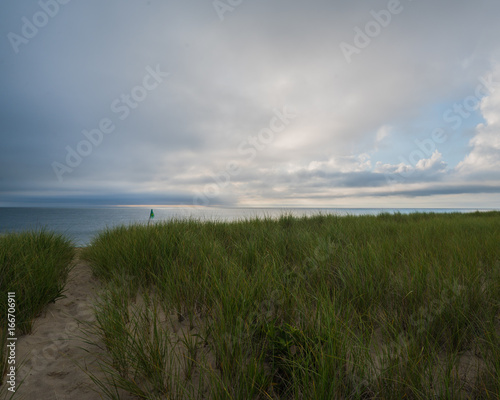 Nantucket ocean beach at sunrise with clouds and seagrass
