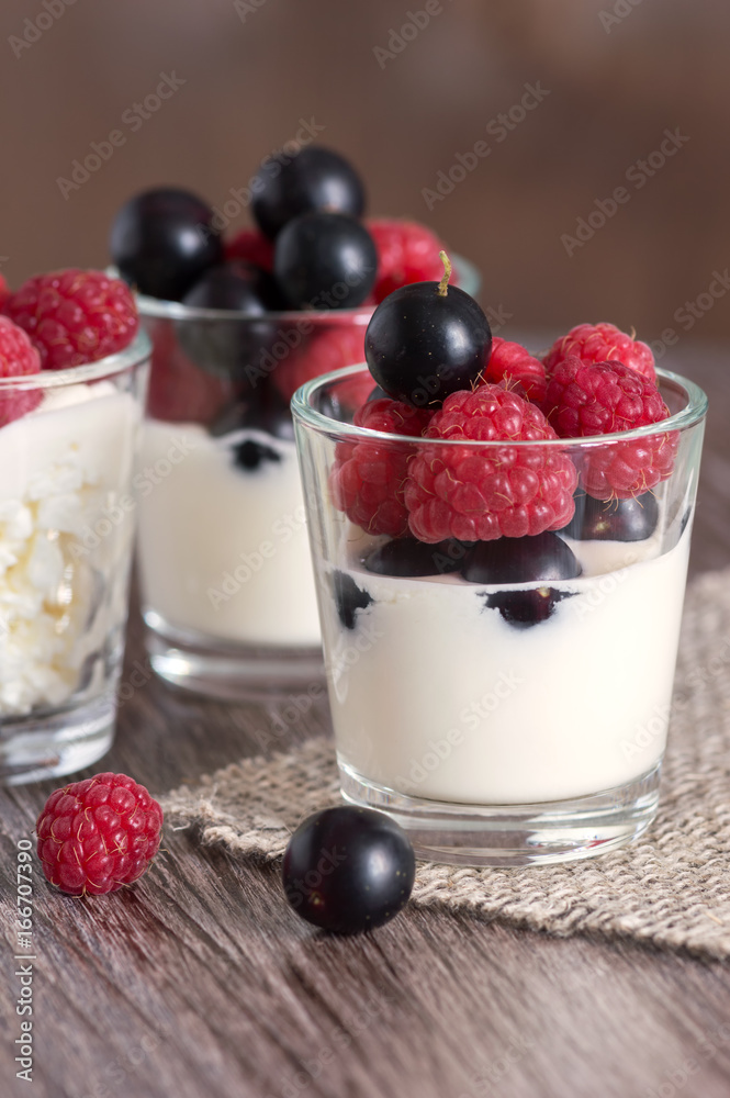 Dairy products with berries. Cheese and cream in a glass with raspberries and currants.