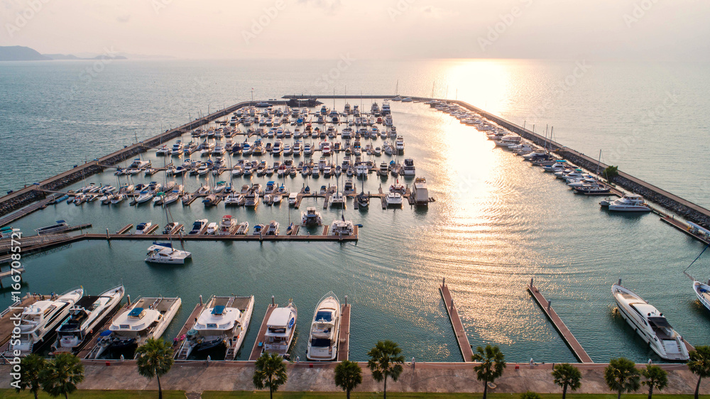 Naklejka premium Pier speedboat. A marina lot. This is usually the most popular tourist attractions on the beach.Yacht and sailboat is moored at the quay.Aerial view by drone.Top view.