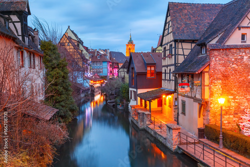 Traditional Alsatian half-timbered houses, church and river Lauch in Petite Venise or little Venice, old town of Colmar, decorated and illuminated at christmas time, Alsace, France