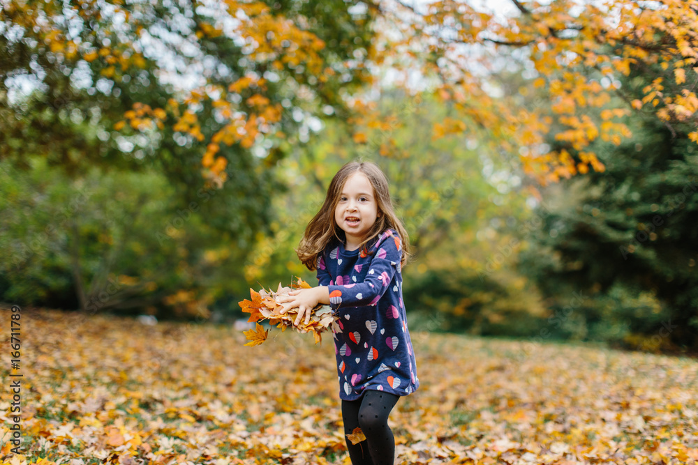 Cute young girl playing with leaves outside Cute young girl playing with leaves outside