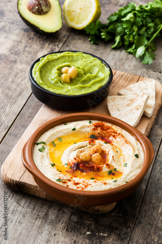 Different hummus bowls. Chickpea hummus  avocado hummus and lentils hummus on wooden table    