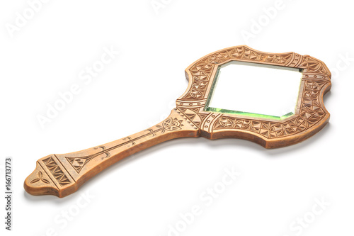 Vintage carved wooden mirror lies on a white background