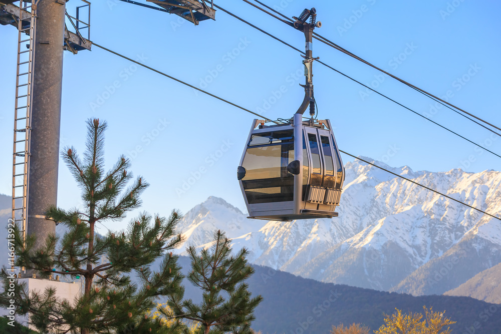 Cabin of funicular on the background of snow-capped mountains at sunset Cabin of funicular on the background of snow-capped mountains at sunset