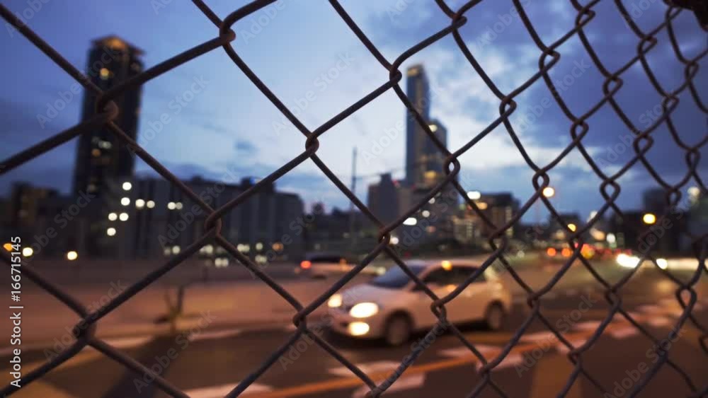 Dusk city highway through the wire mesh fence Dusk city highway through the wire mesh fence