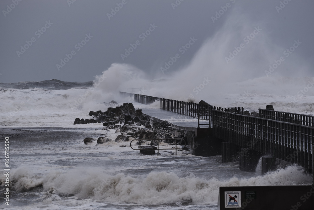    waves hitting against the pier during the storm in Nr. Vorupoer on the North Sea coast in Denmark            