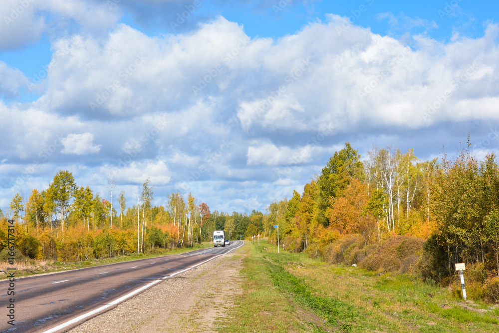 Beautiful and sunny road landscape with sky clouds and yellow trees. Way to nowhere
