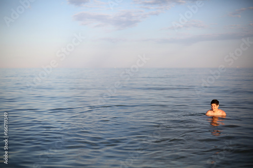 Young boy with brown hair while bathing in the sea