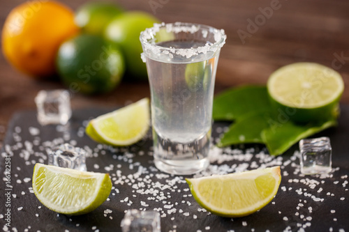 Mexican tequila in short glasses with salt, lime slices and ice.