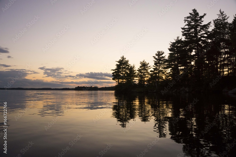 Sunset on a lake with an island silhouette and reflection