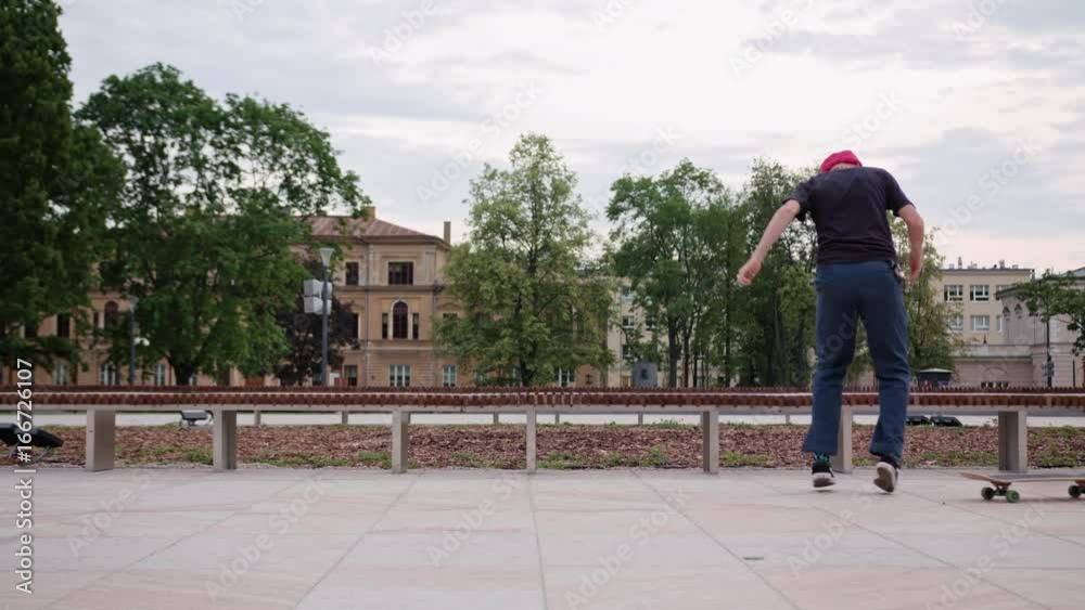 Young readhead hispter with beard and moustaches in jeans and T-shirt rides a skateboard and makes a flip. Outdoor. Cloudy. Wide angle. Stabilised. Slow motion Young readhead hispter with beard and moustaches in jeans and T-shirt rides a skateboard and makes a flip. Outdoor. Cloudy. Wide angle. Stabilised. Slow motion
