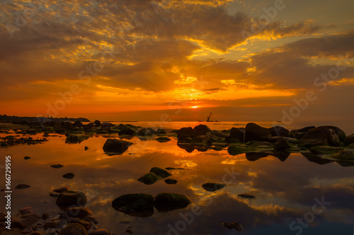 Sunset over the sea, stones at foreground © Anton Gvozdikov