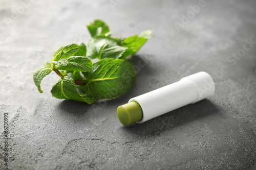 Hygienic lipstick with lemon balm on table