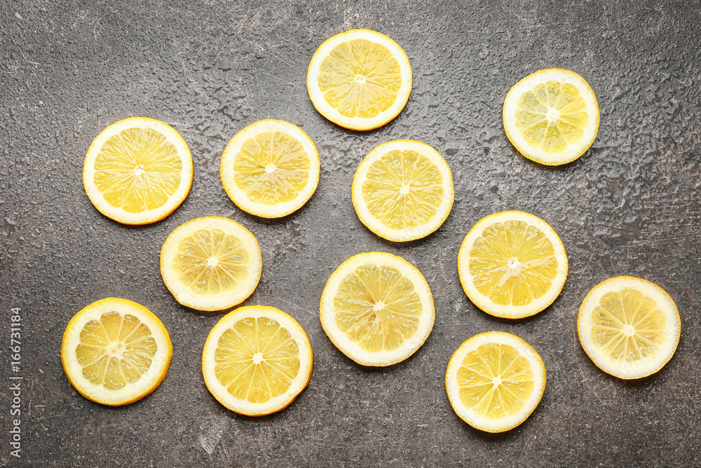 Delicious sliced citrus fruit and green leaves on grey background