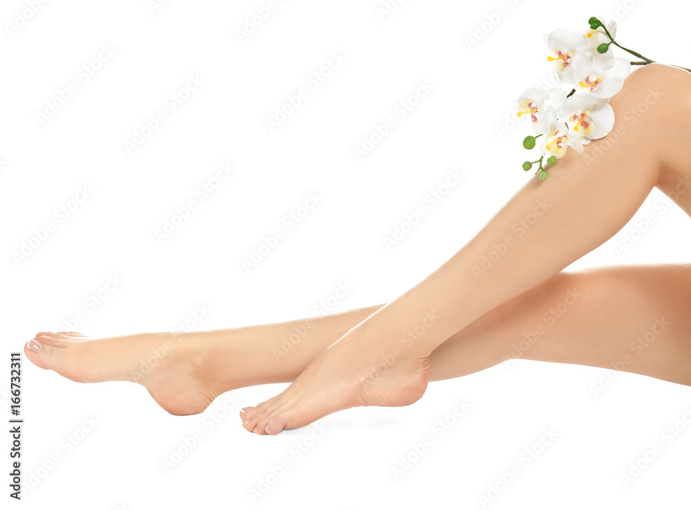 Epilation concept. Legs of beautiful young woman with orchid on white background