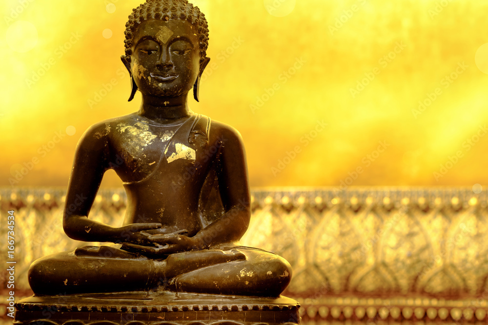Fototapeta premium Buddha statue of meditation pose in peaceful atmosphere. Golden background is part of huge reclining Buddha statue in a famous temple in Bangkok , Thailand and popular tourist place