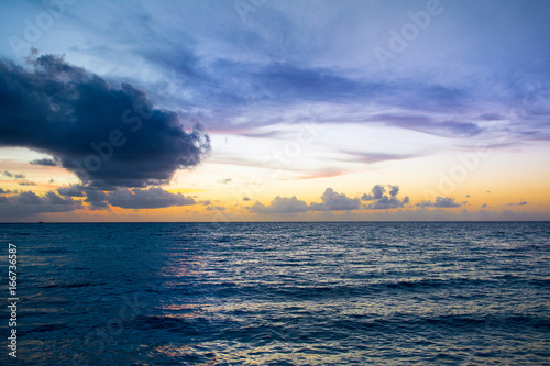 Landscape of beautiful sunset in Maldives island sandy beach with colorful sky over wavy sea
