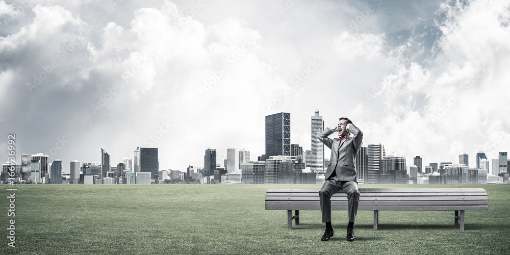 Young man in suit in park dont want to hear anything