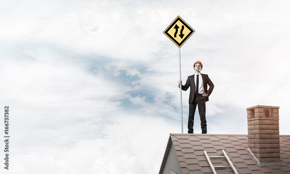 Engineer man on brick roof with sign in hands. Mixed media