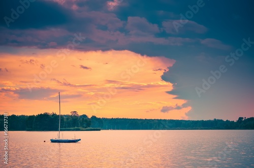 Boat on the water. Evening landscape by the lake. © shadowmoon30