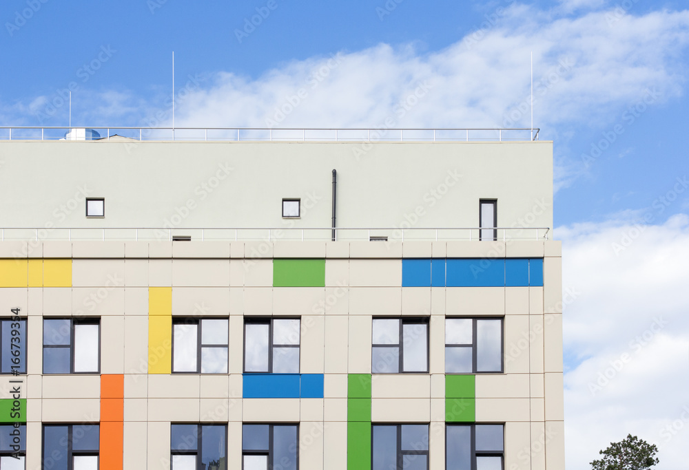 Multicolored facade against the blue sky with clouds