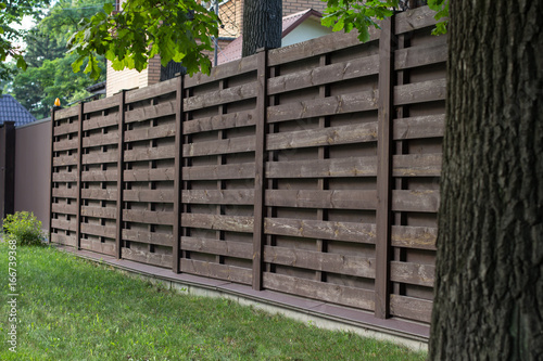 Принти на полотні Wooden fence in Scandinavian style, on a green lawn