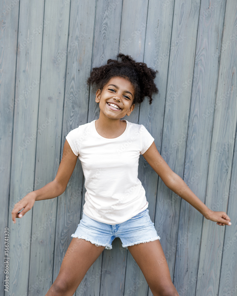 Adorable little girl posing at wall outdoors Adorable little girl posing at wall outdoors