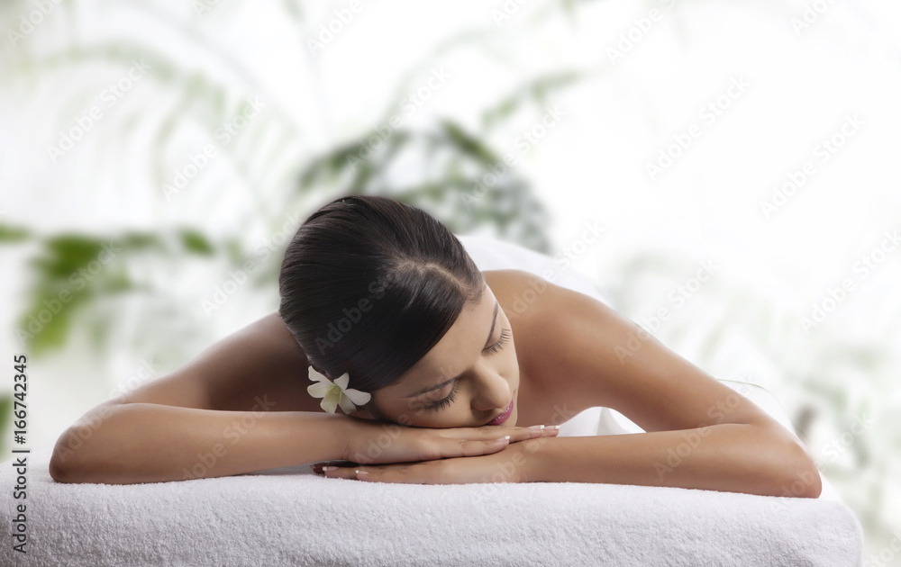 Woman with eyes closed lying on message table Woman with eyes closed lying on message table