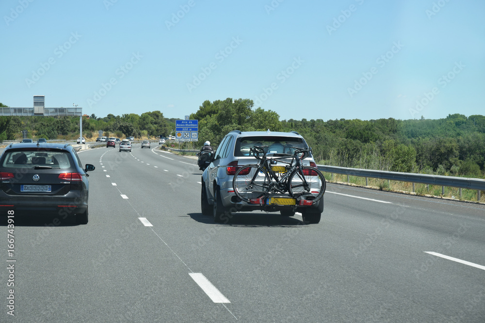Sur l'autoroute : voiture équipée d'un porte-vélos à l'arrière.