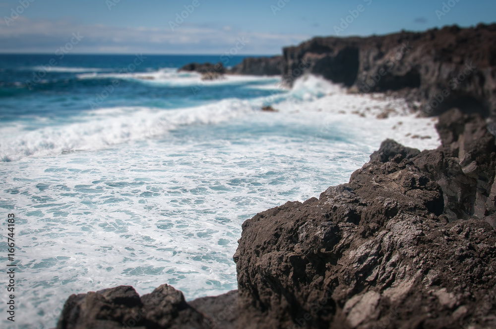 Lanzarote volcanic coastline with oceanic waves tilt shift effect